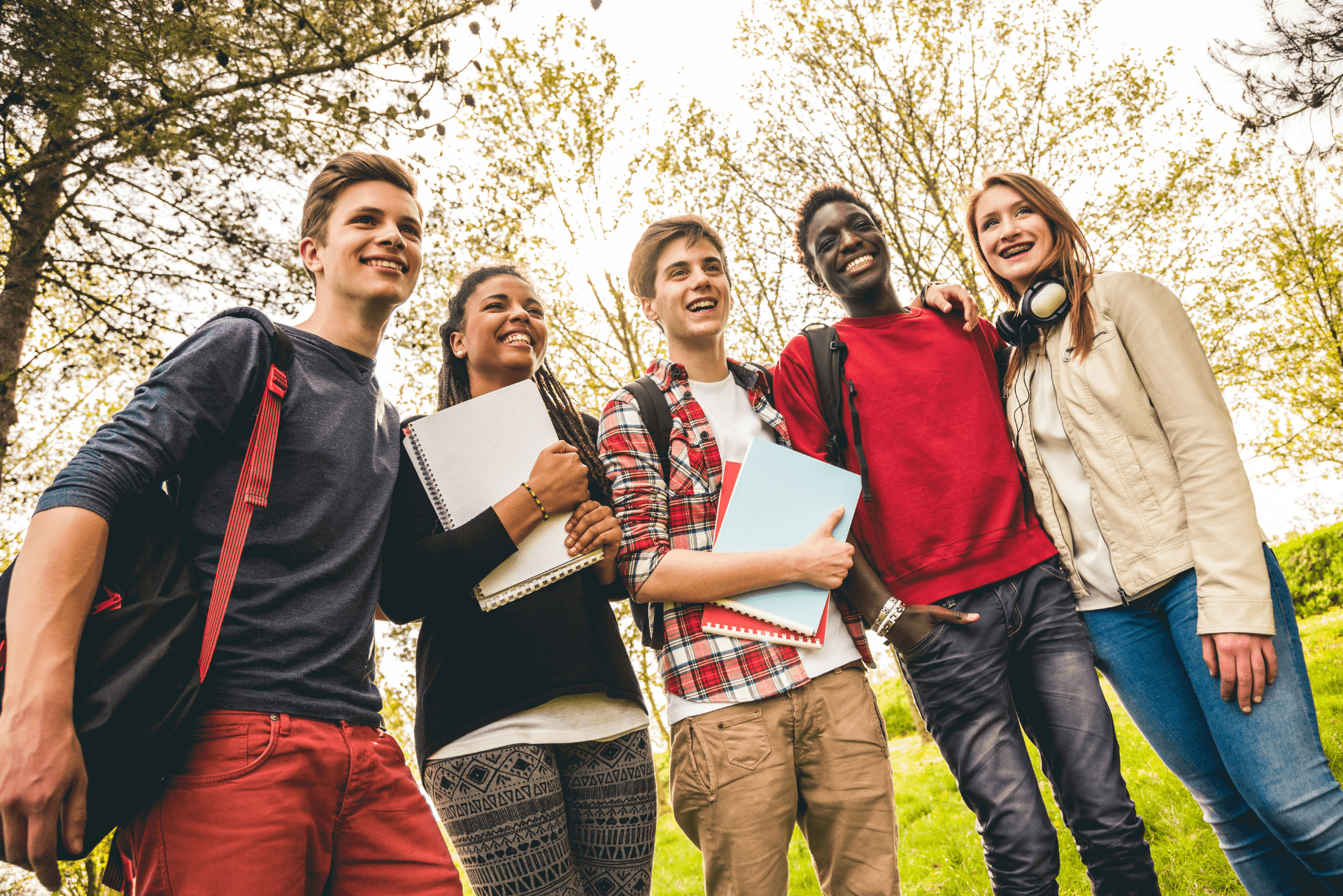 Gruppo di studenti sorridenti con zaini pronti per andare a scuola
